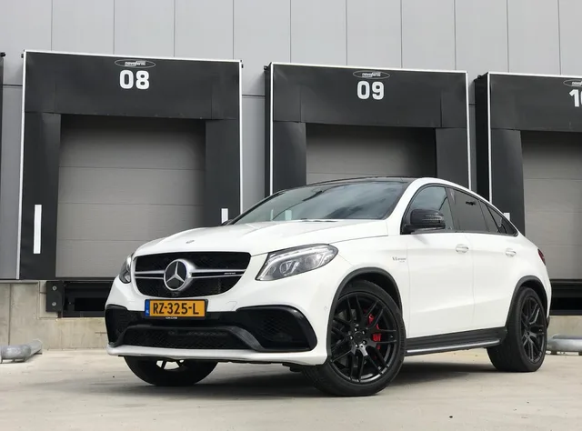 White Mercedes GLE coupe parked in front of numbered black loading docks