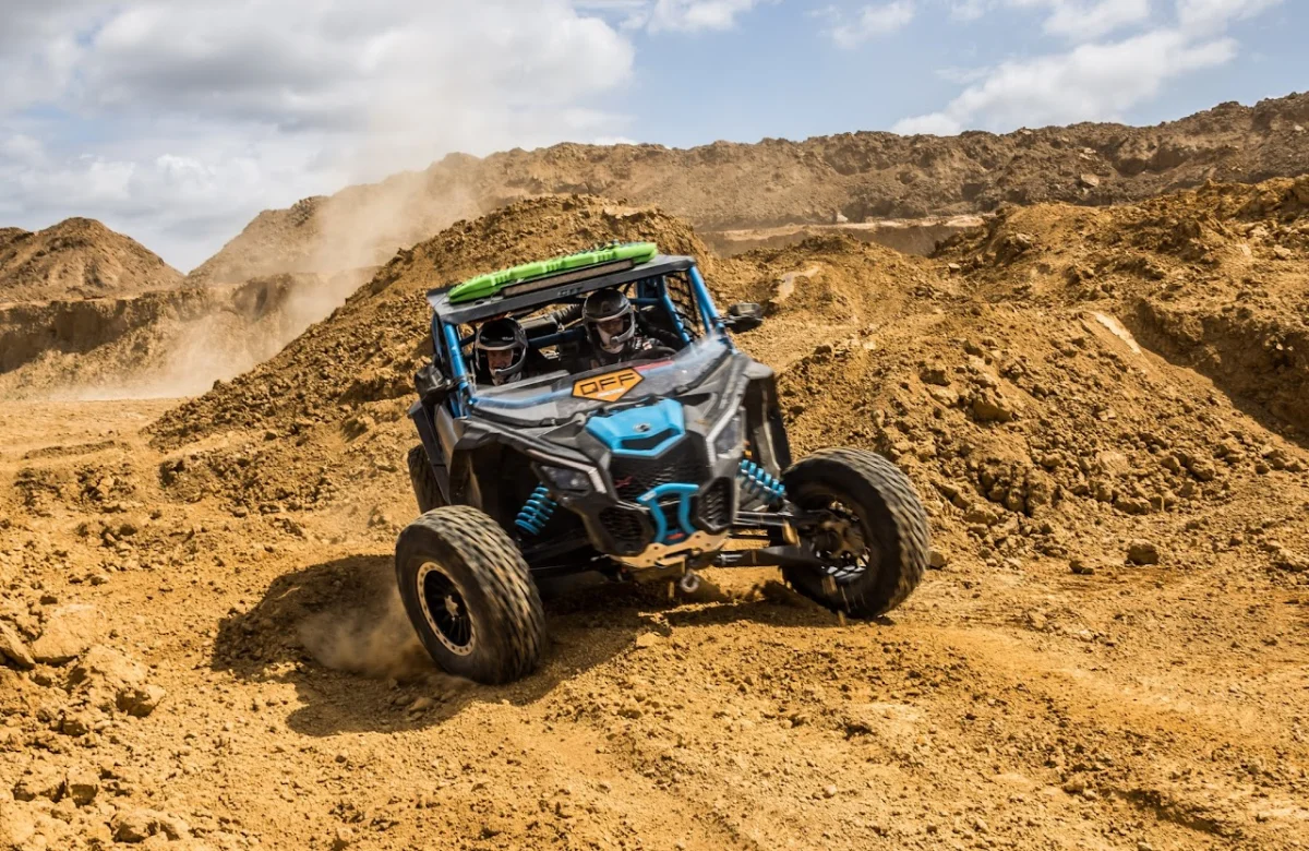Off-road buggy kicking up dust through a sand quarry