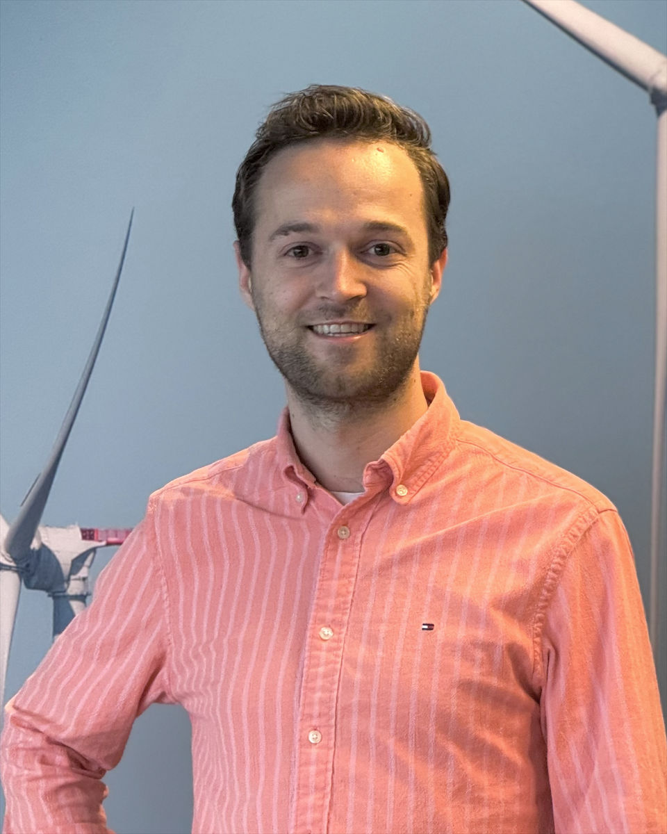 Portrait of Mayk Thewessen in front of an offshore wind turbine photo wall
